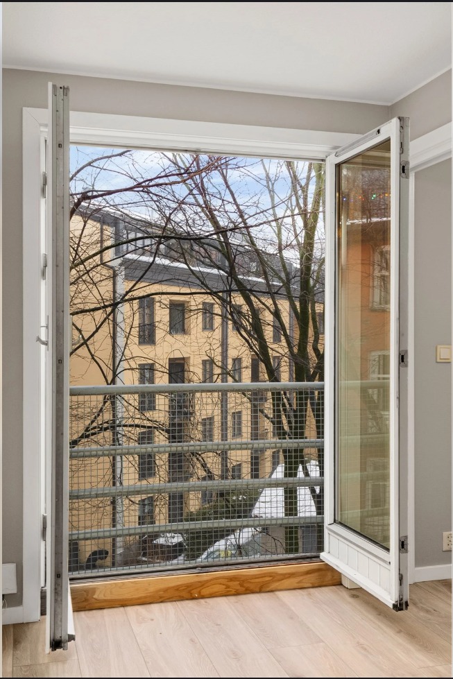 Fransk balkong ut til en rolig bakgård gir et lyst og luftig inntrykk.